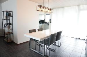 een eettafel en stoelen in een keuken bij Kustverhuur, Prachtig appartement met uitzicht op zee, Port Scaldis 09-051 in Breskens