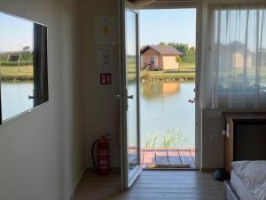 una camera con porta che si apre su una vista sul lago di Ranč Ramarin a Garčin