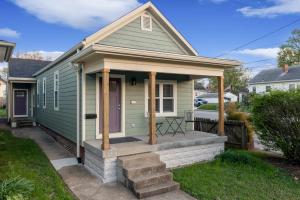 een klein groen huis met een veranda en een trap bij Highlands Home With Garage in Louisville