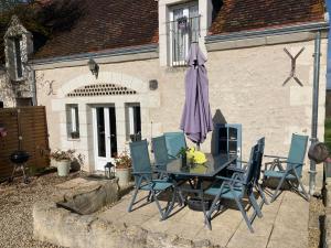 a patio with a table and chairs and an umbrella at Bblodges Loches Beauval in Saint-Hippolyte