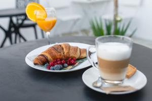 a plate of bread and a glass of orange juice at Privilege Suite Pieta in Tal-Pietà