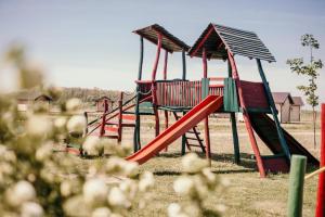 un parque infantil con un tobogán rojo en un campo en Ranč Ramarin en Garčin