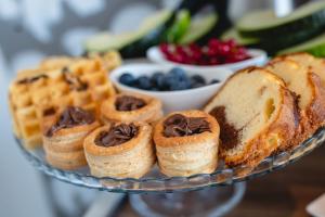 a glass plate with pastries and bread and waffles at Privilege Suite Pieta in Tal-Pietà
