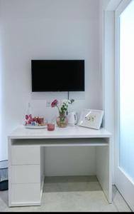 a white table with a television on a wall at Privilege Suite Pieta in Tal-Pietà