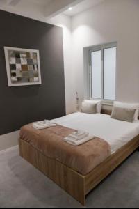 um quarto com uma cama grande e toalhas em Privilege Suite Pieta em Tal-Pietà