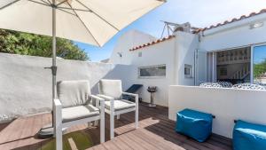 a patio with two chairs and an umbrella at Relaxing Beach House in Alfamar by LovelyStay in Albufeira
