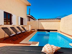 a swimming pool on the side of a house at Beach & Pool House @ Mindelo in Vila Chã