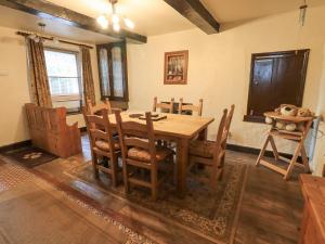 a dining room with a wooden table and chairs at Springwell Cottage in Ambleside