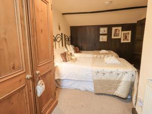 a bedroom with a large bed with white sheets at Springwell Cottage in Ambleside