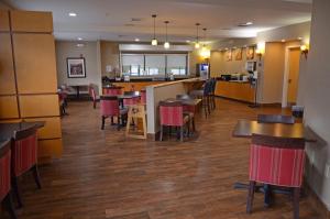 a restaurant with tables and chairs and a kitchen at Comfort Suites Salem-Roanoke I-81 in Salem