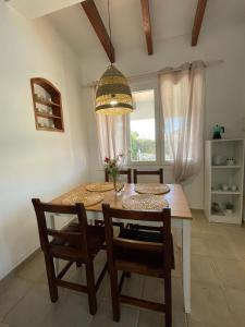 uma sala de jantar com uma mesa e cadeiras e uma janela em Las Margaritas Binibeca Menorca em Binibeca
