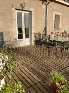 a deck with a glass table and chairs on it at Bblodges Loches Beauval in Saint-Hippolyte