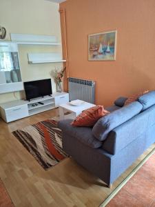 a living room with a couch and a tv at Apartments Gojka Miocevic in Biograd na Moru
