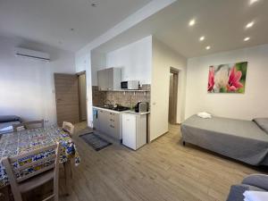a room with a bed and a kitchen with a table at Casabella in Giarre