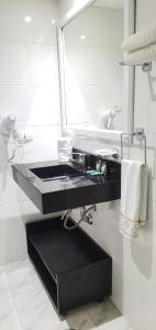 baño con lavabo negro y espejo en Flat Alameda Lorena - Prédio Ninety - Jardim Paulista, en São Paulo