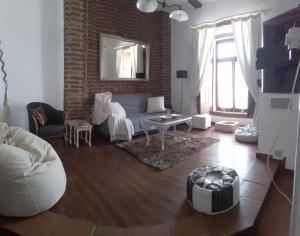 a living room with a couch and a brick wall at Casa das Viagens in Ferreira do Alentejo