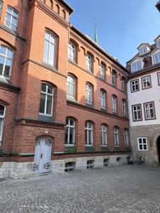 ein großes rotes Backsteingebäude mit einer weißen Tür in der Unterkunft RAHA - Historischer Charme direkt am Domplatz in Erfurt