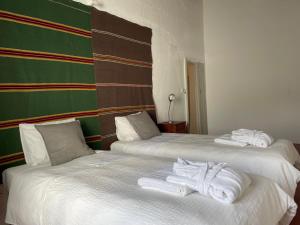 2 camas con toallas en una habitación en Casa Ancha, en Beja