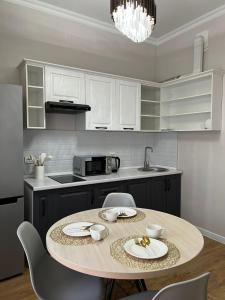 uma cozinha com uma mesa e cadeiras numa cozinha em Жилой комплекс Легенда em (( Gornyy Gigant ))