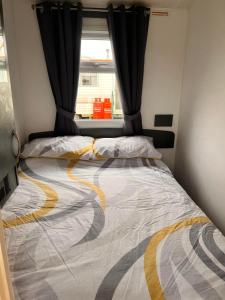 a large bed in a room with a window at Northumberland Caravan Holiday in Cresswell