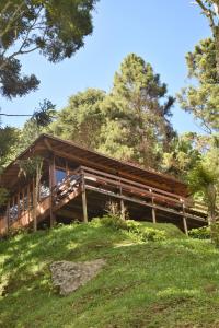 drewniany dom na szczycie wzgórza w obiekcie Chalé aconchegante cercado pelo verde w mieście Nova Friburgo