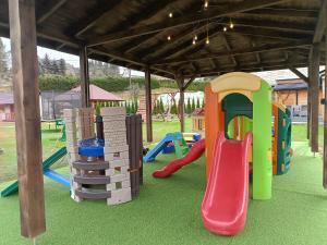 a play area with a playground with a slide at Domki nad Strumykiem in Ustrzyki Dolne