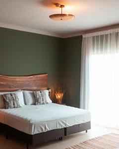 1 dormitorio con cama y pared verde en Selina Bonito, en Bonito