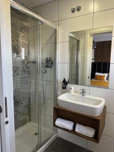 La salle de bains est pourvue d'un lavabo et d'une douche. dans l'établissement Hotel Don Rodrigues, à Tavira