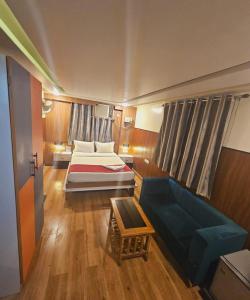 ein kleines Zimmer mit einem Bett und einem Sofa in der Unterkunft HOTEL Bodhi Tree in Patna