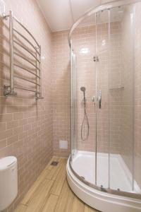 ein Badezimmer mit einer Dusche, einer Badewanne und einem WC in der Unterkunft DREAM Hotel Lviv in Lwiw