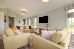 a living room with two couches and a flat screen tv at 6 Faraway Fields in Liskeard