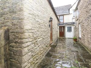 an alley in an old stone building with a door at Bobbin Cottage in Swanage