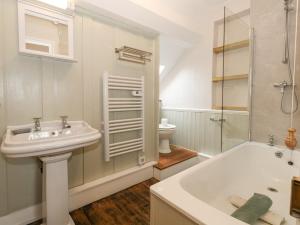 a bathroom with a sink and a tub and a toilet at Bobbin Cottage in Swanage