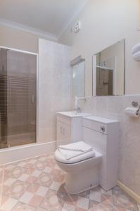 a white bathroom with a toilet and a sink at Bridge House Hotel in Birmingham