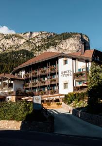 un bâtiment d'hôtel avec une montagne en arrière-plan dans l'établissement Hotel Tyrol, à Selva di Val Gardena