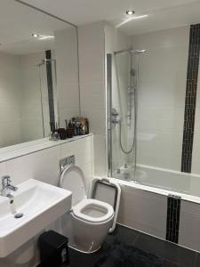a bathroom with a toilet and a sink and a shower at Inviting 2-Bed Apartment in Bushey in Bushey