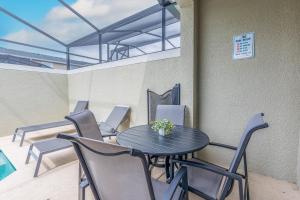 a table and chairs on a balcony with a table at TVPM-4263PD SL townhouse in Kissimmee