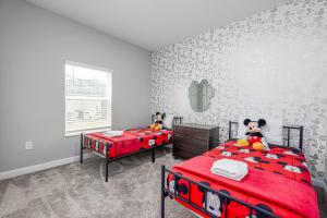 a bedroom with two beds and a mickey mouse wallpaper at TVPM-4263PD SL townhouse in Kissimmee