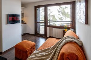 a living room with a couch and a large window at Cervino View - 3 minuti a piedi dalle piste da scii - Parcheggio gratuito in Breuil-Cervinia