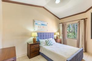Un dormitorio con una cama azul y una ventana en Luxury Coco Villas en Coco