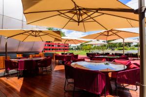 a restaurant with tables and chairs with umbrellas at Golden Tulip Brasília Alvorada in Brasília