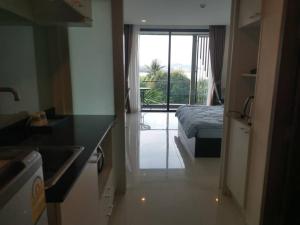 a room with a bed and a kitchen with a window at The Pixel Cape Panwa Beach Condo in Panwa Beach