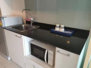 a kitchen with a sink and a microwave at The Pixel Cape Panwa Beach Condo in Panwa Beach +10 photos