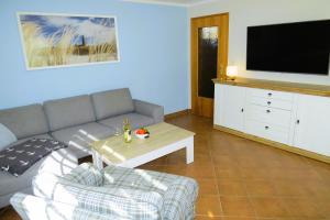 a living room with a couch and a tv at Ferienhaus Prerow in Prerow