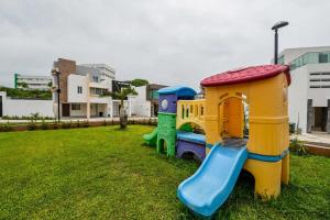 zwei Kinderspielplätze auf einem Rasenplatz in der Unterkunft Beautiful Apt Near the Beach in Boca del Río