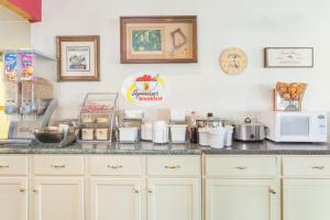 a kitchen with white cabinets and a counter top at Super 8 by Wyndham Carthage in Carthage