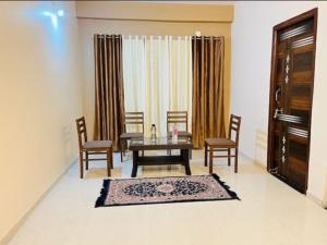 a dining room with a table and chairs and a window at HOTEL GREEN villa in Rewa