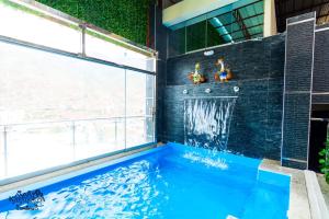 a swimming pool in a building with a large window at Hotel Kapadokya in Huánuco