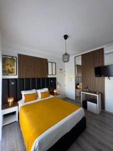 - une chambre avec un grand lit et une couverture jaune dans l'établissement Hotel Don Rodrigues, à Tavira