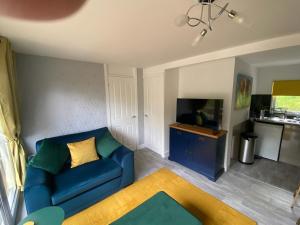 a living room with a blue couch and a tv at Betty’s Hideaway in Caernarfon